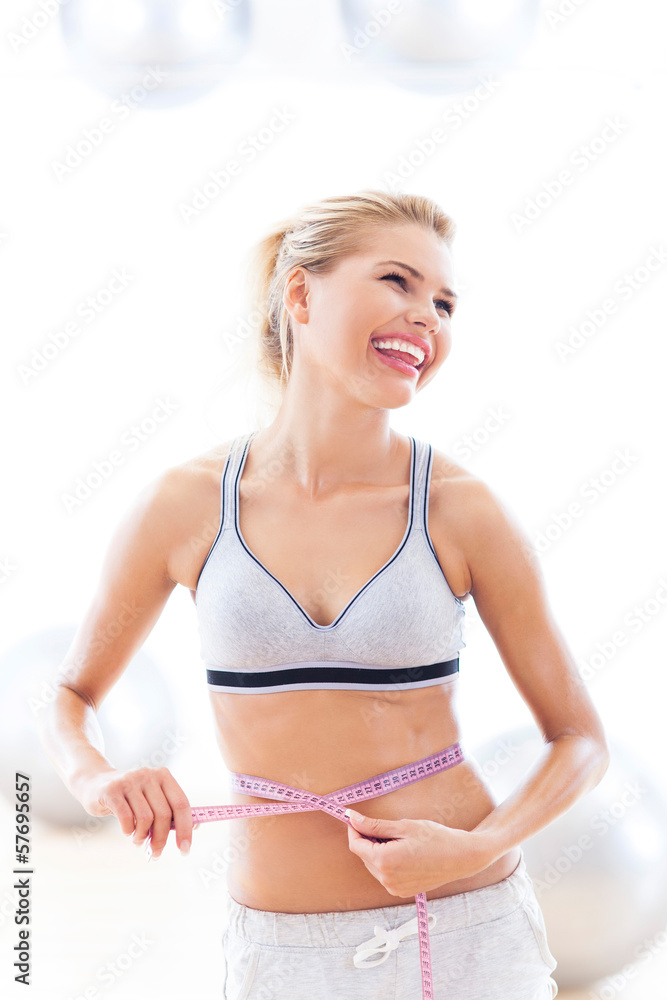 Woman measuring waist with tape measure Woman measuring waist with tape measure