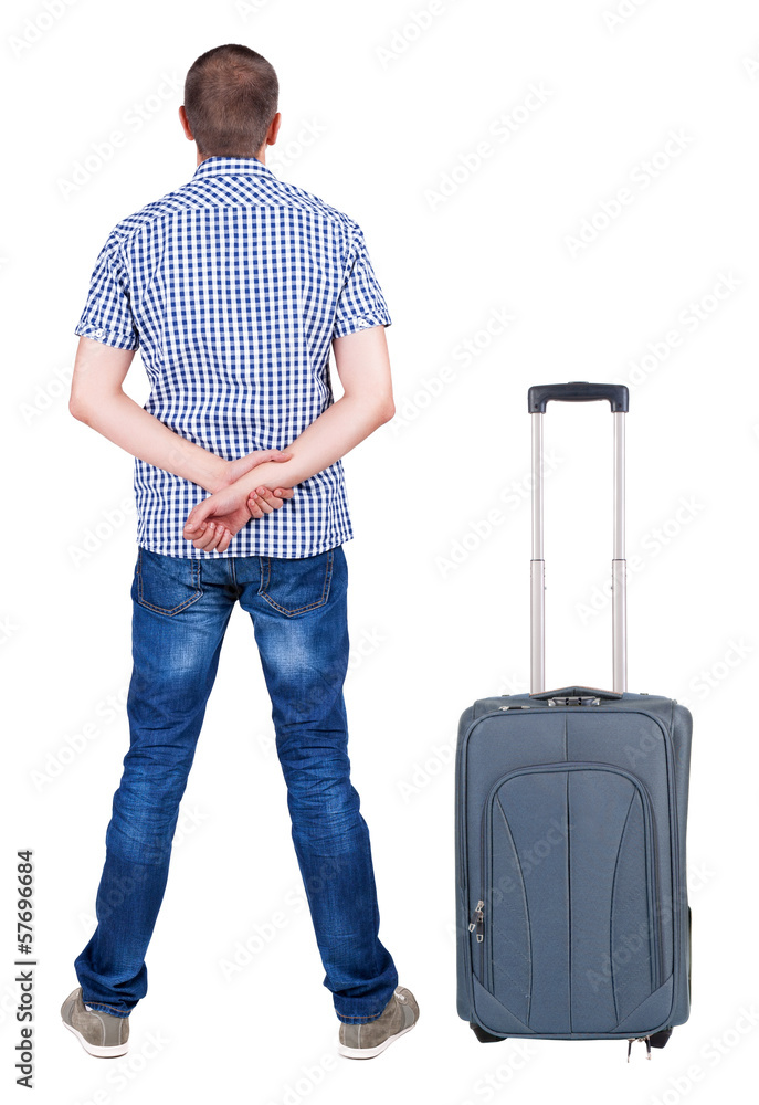 Back view of young man traveling with suitcas. Back view of young man traveling with suitcas.