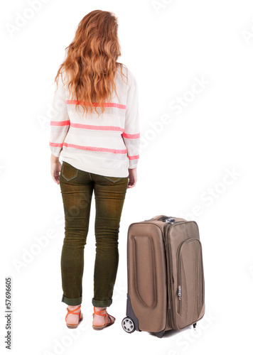 back view of walking woman with suitcase.