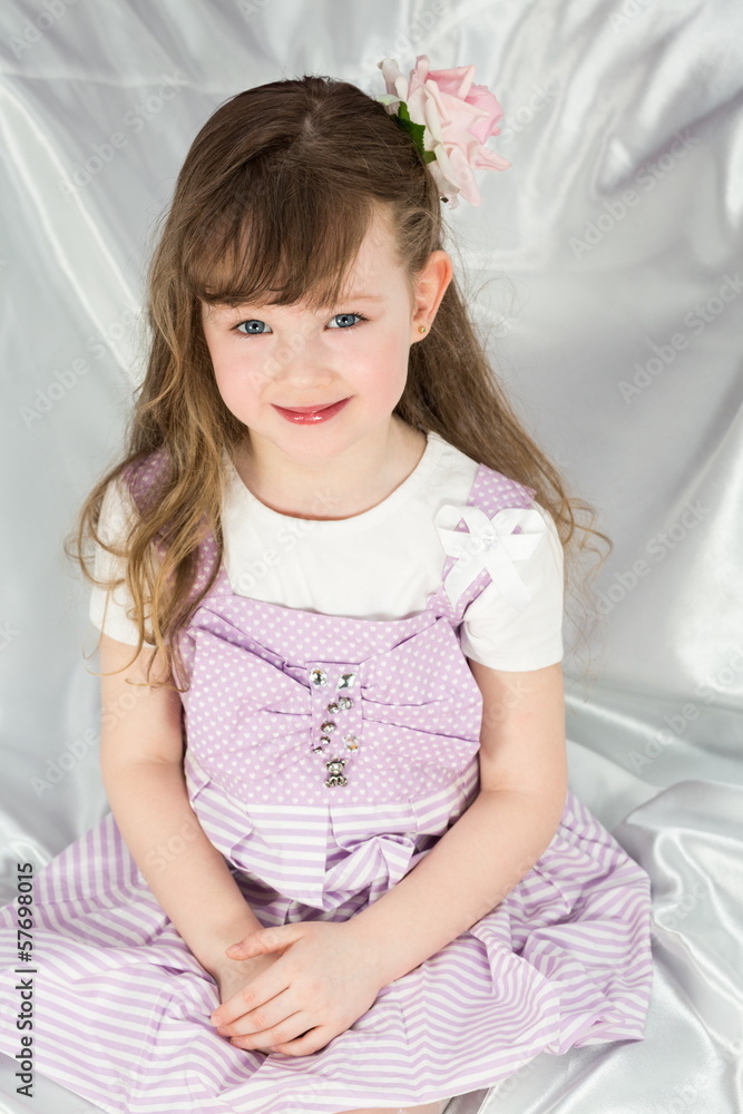 Cute little girl in a beautiful dress with flower on hair Cute little girl in a beautiful dress with flower on hair