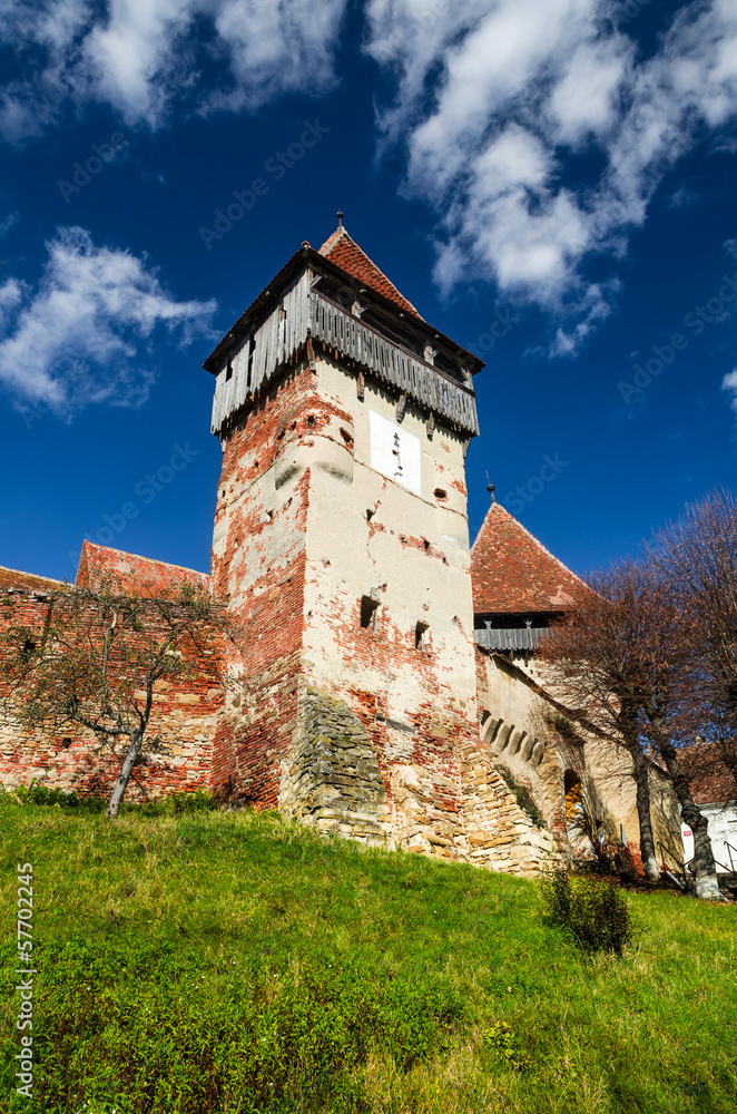 Tower and walls of fortified church Alma Vii, Transylvania. Roma