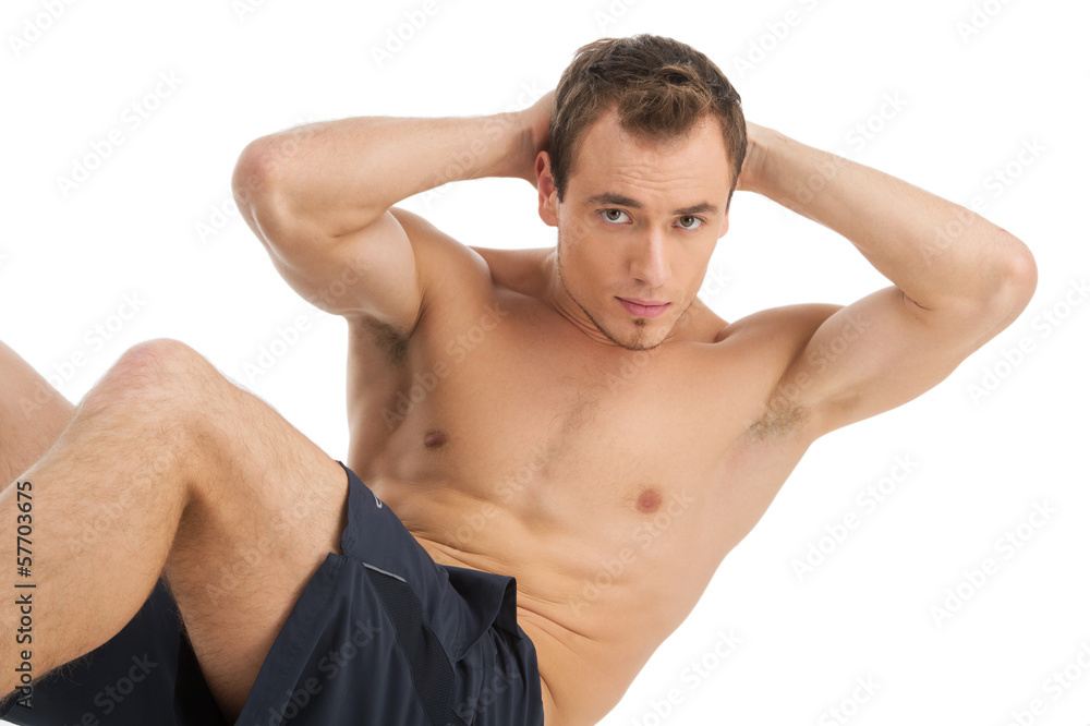 Handsome muscular man doing sit-ups on a floor. Handsome muscular man doing sit-ups on a floor.