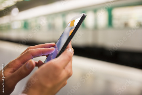 Woman using her cell phone on subway platform