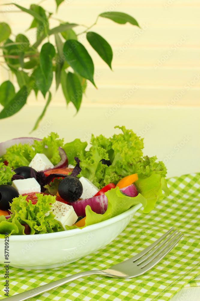 Greek salad on plate on table on light background Greek salad on plate on table on light background