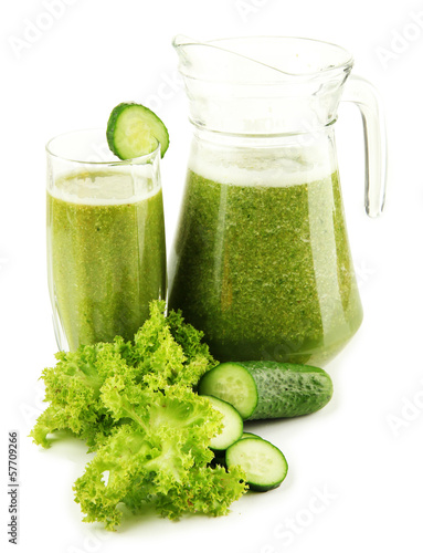 Glass and jug of green vegetable juice with cucumber isolated