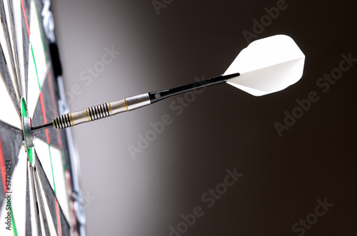Dart in bulls eye of dartboard