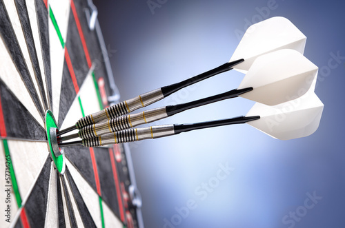 Three darts in bullseye of dartboard