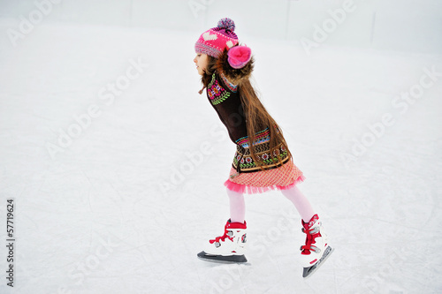 Adorable little girl on the ice rink