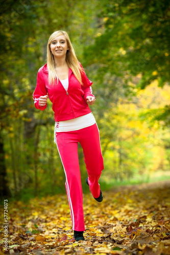 Fototapeta Naklejka Na Ścianę i Meble -  Woman running in autumn forest.  Female runner training.
