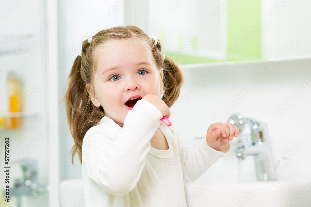 Child girl brushing teeth in bathroom Child girl brushing teeth in bathroom