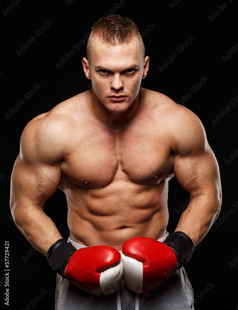 Handsome muscular young man wearing boxing gloves Handsome muscular young man wearing boxing gloves