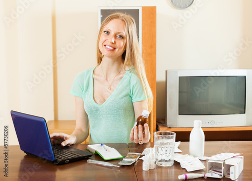 Happy  woman reading about medications in internet photo