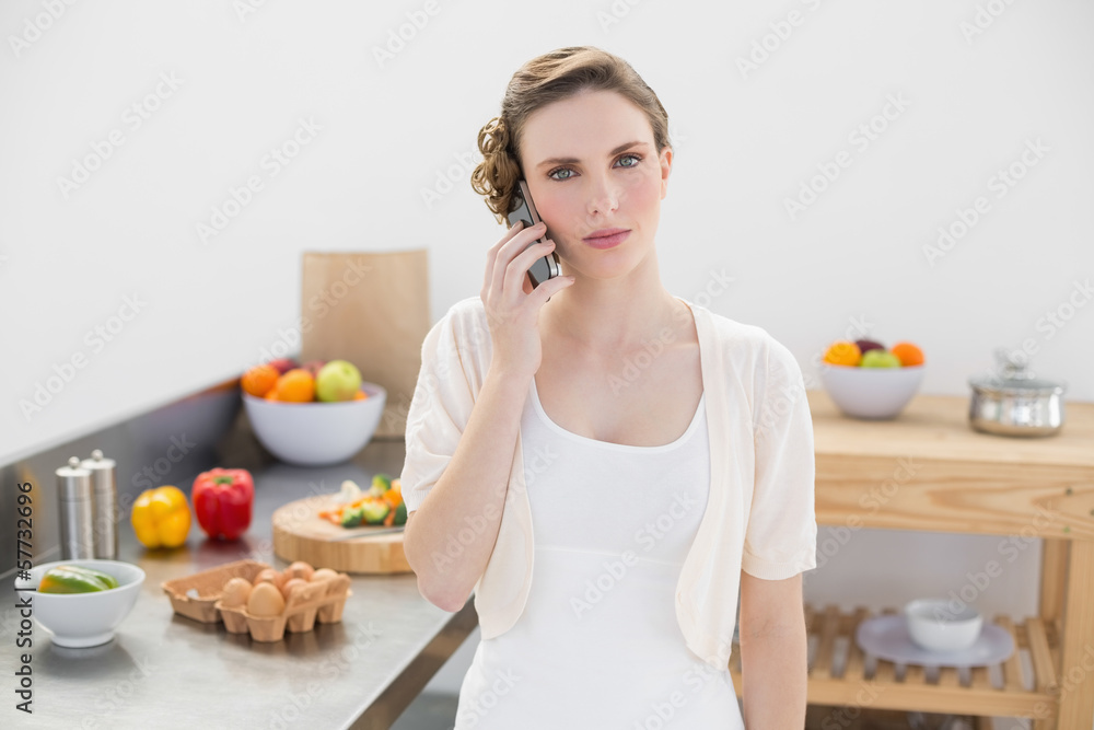 Young woman standing in kitchen while phoning Young woman standing in kitchen while phoning