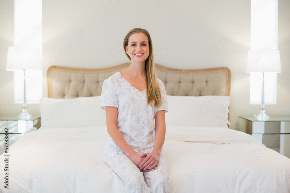 Natural cheerful woman sitting on bed Natural cheerful woman sitting on bed