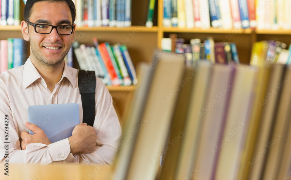 Smiling mature student with tablet PC in library Smiling mature student with tablet PC in library