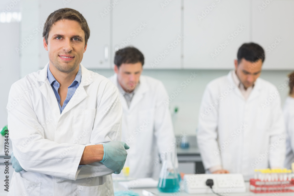 Smiling scientist with colleagues at work in the lab