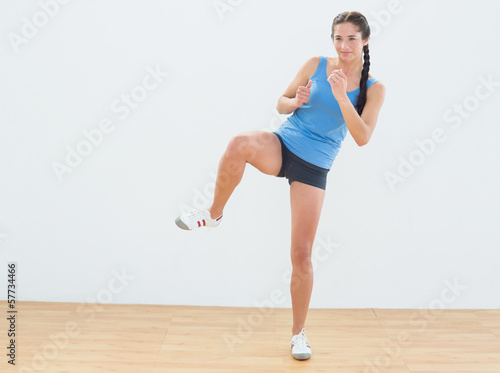 Sporty woman stretching leg in fitness center