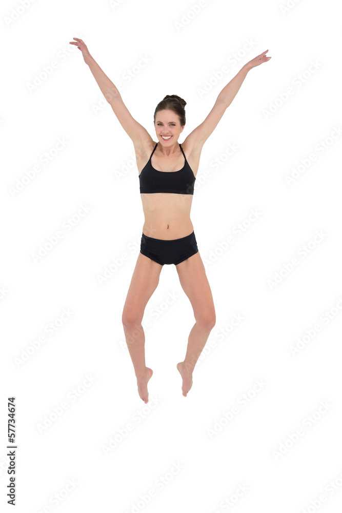 Sporty young woman jumping isolated on white background