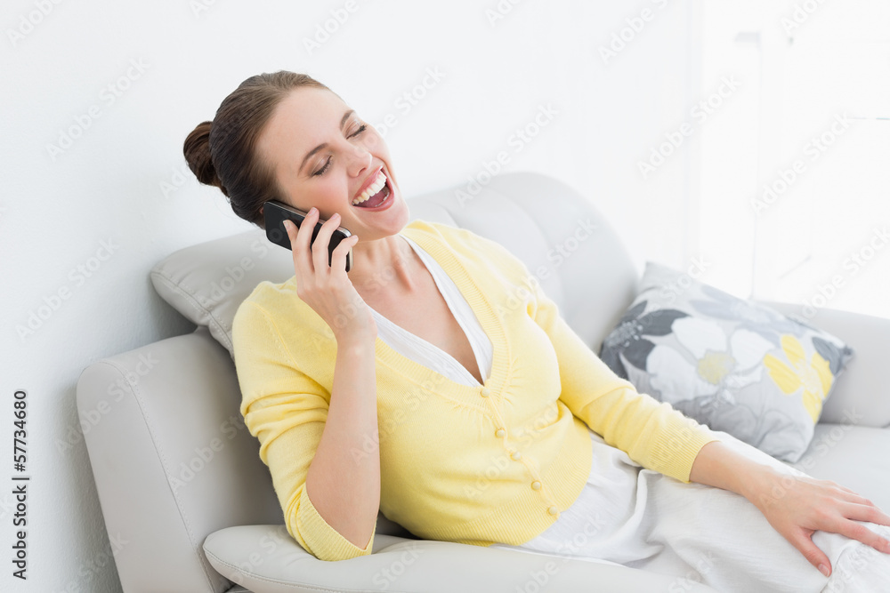 Cheerful woman using mobile phone on sofa Cheerful woman using mobile phone on sofa