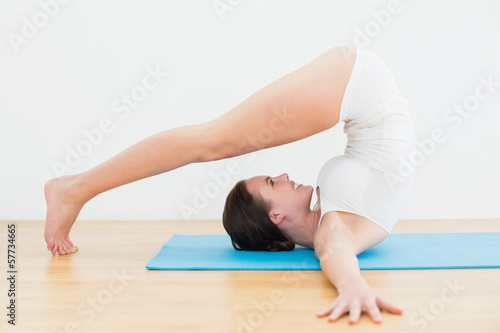 Side view of a woman exercising on mat