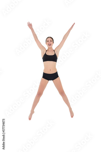 Sporty young woman jumping isolated on white background