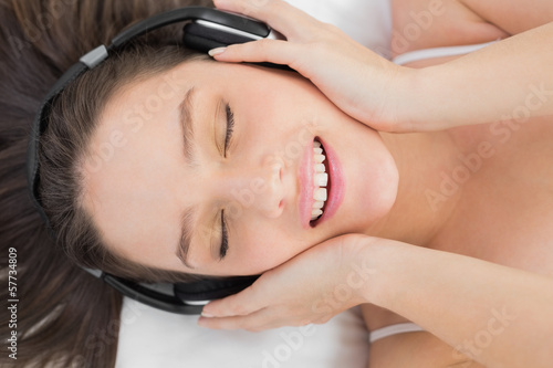 Woman enjoying music in bed