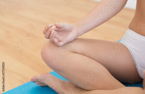 Close-up of a slim cropped woman in lotus pose