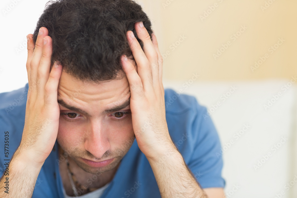 Fototapeta premium Casual troubled man sitting on couch