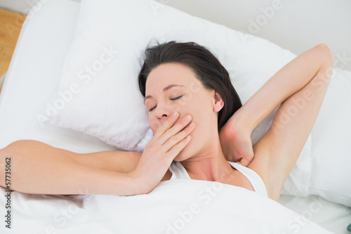 Close-up of a beautiful woman yawning in bed