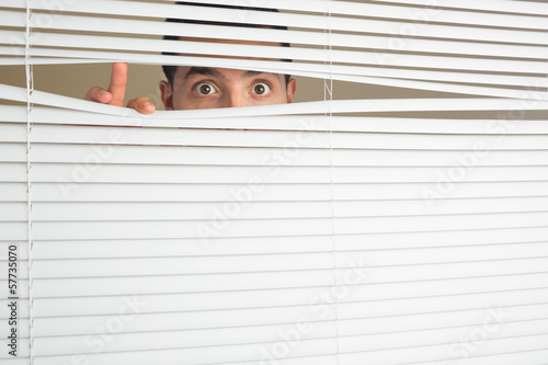 Photos Shocked male eyes spying through roller blind