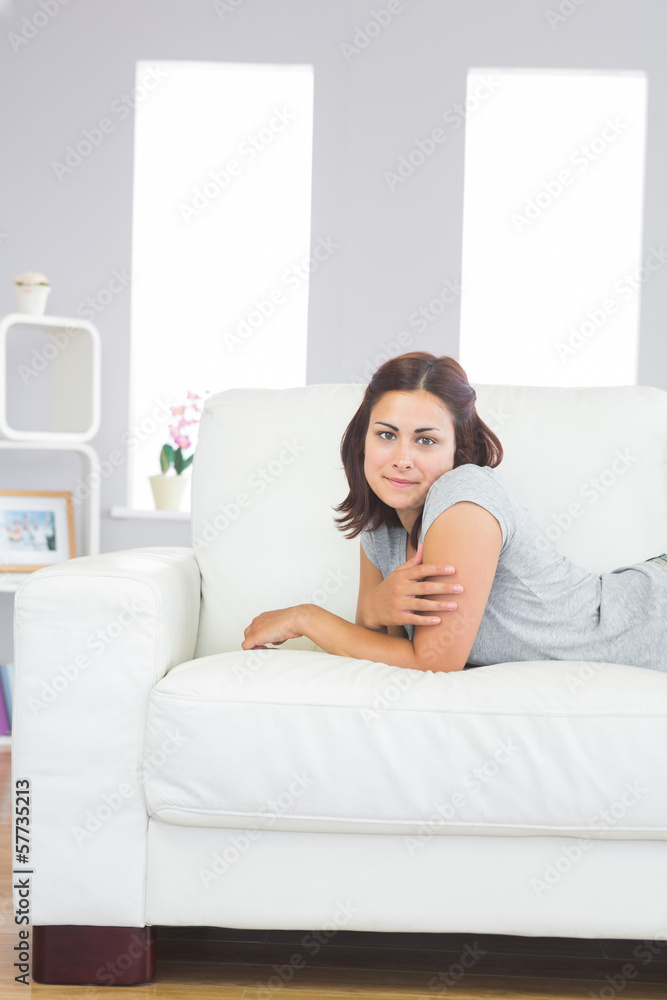 Attractive calm woman lying on a white couch Attractive calm woman lying on a white couch