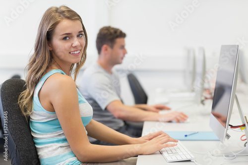 Two smiling students working on computer individually © WavebreakMediaMicro