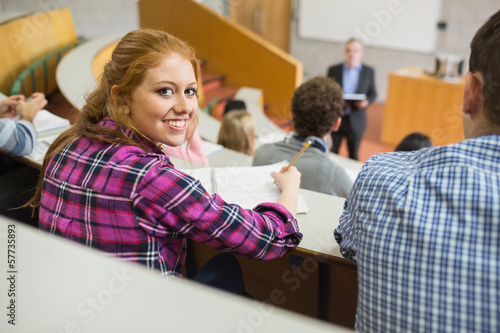 Fotografi Smiling female with students and teacher in lecture hall