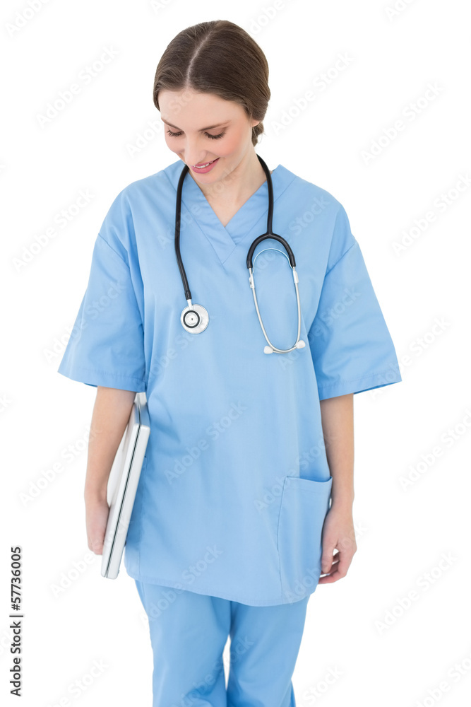 Young female doctor holding a white notebook and looking down Young female doctor holding a white notebook and looking down