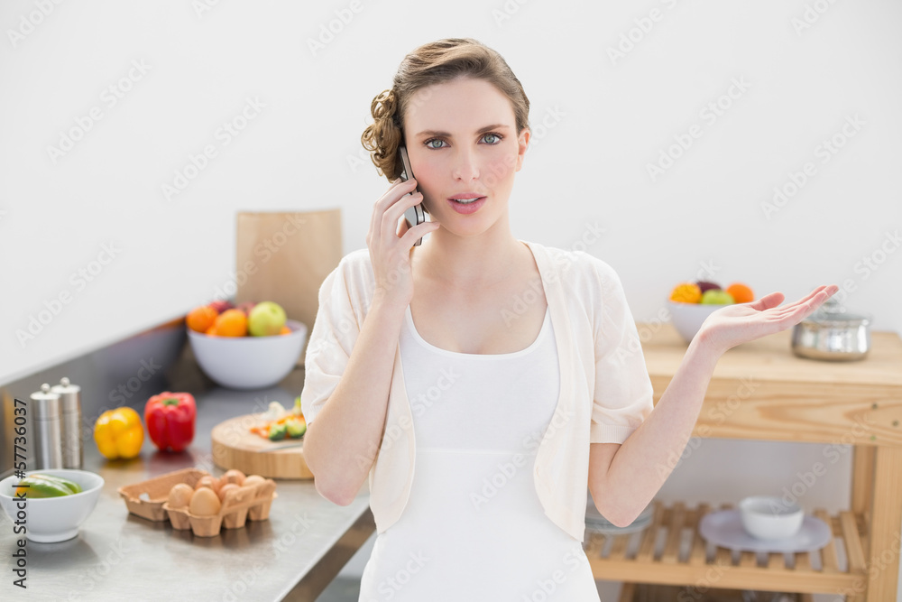 Attractive young woman discussing on the phone standing in the k Attractive young woman discussing on the phone standing in the k