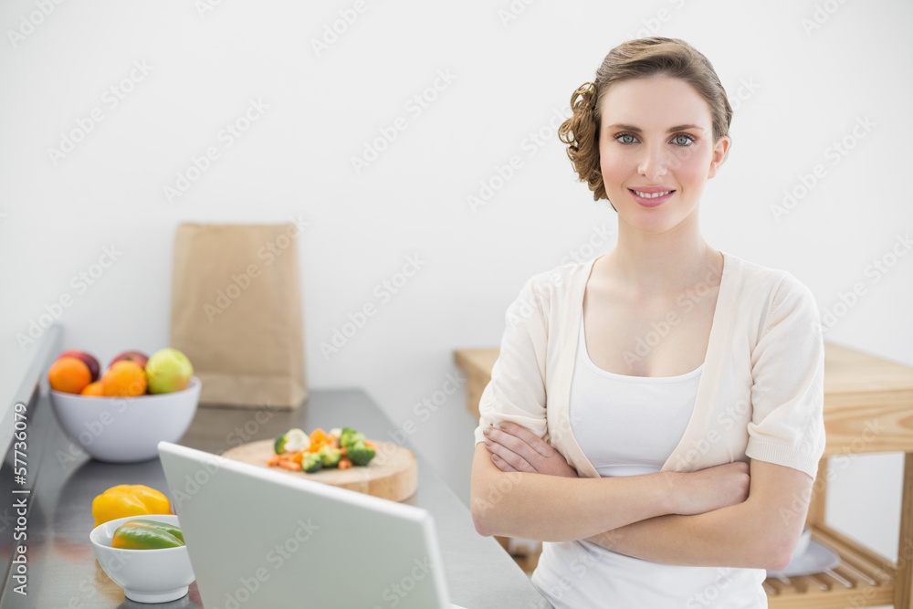 Young beautiful woman posing in he kitchen with arms crossed