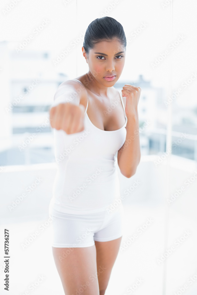 Serious toned brunette boxing towards camera Serious toned brunette boxing towards camera