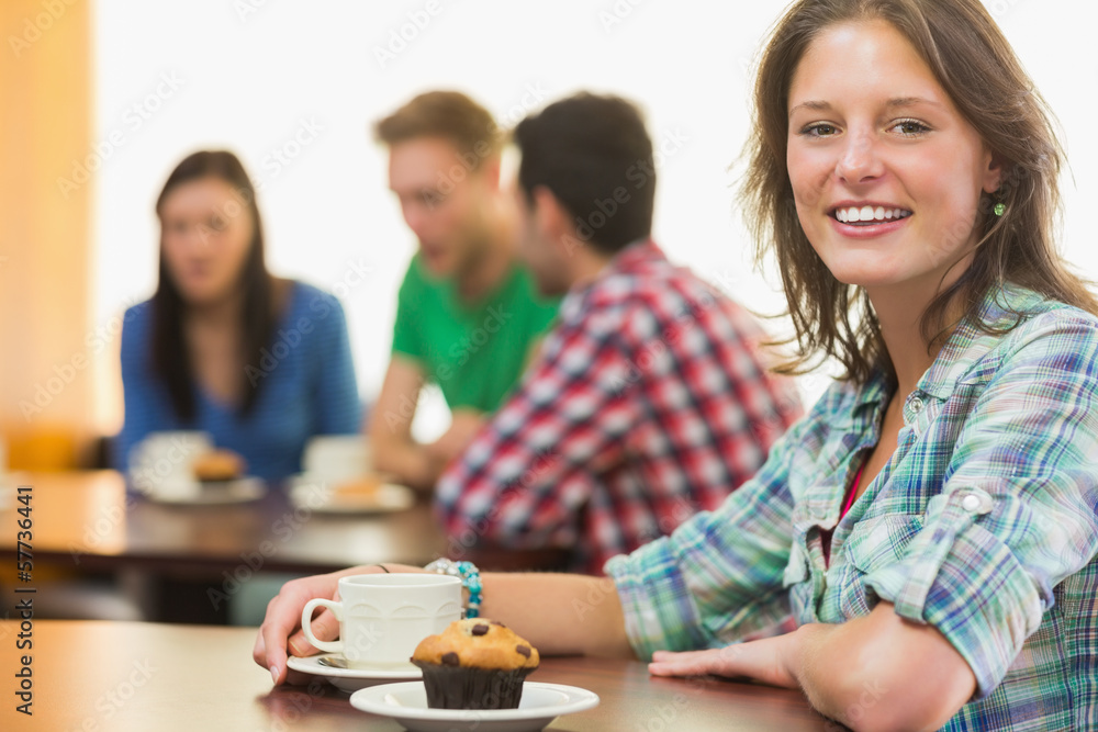 Smiling female having coffee and muffin at coffee shop Smiling female having coffee and muffin at coffee shop