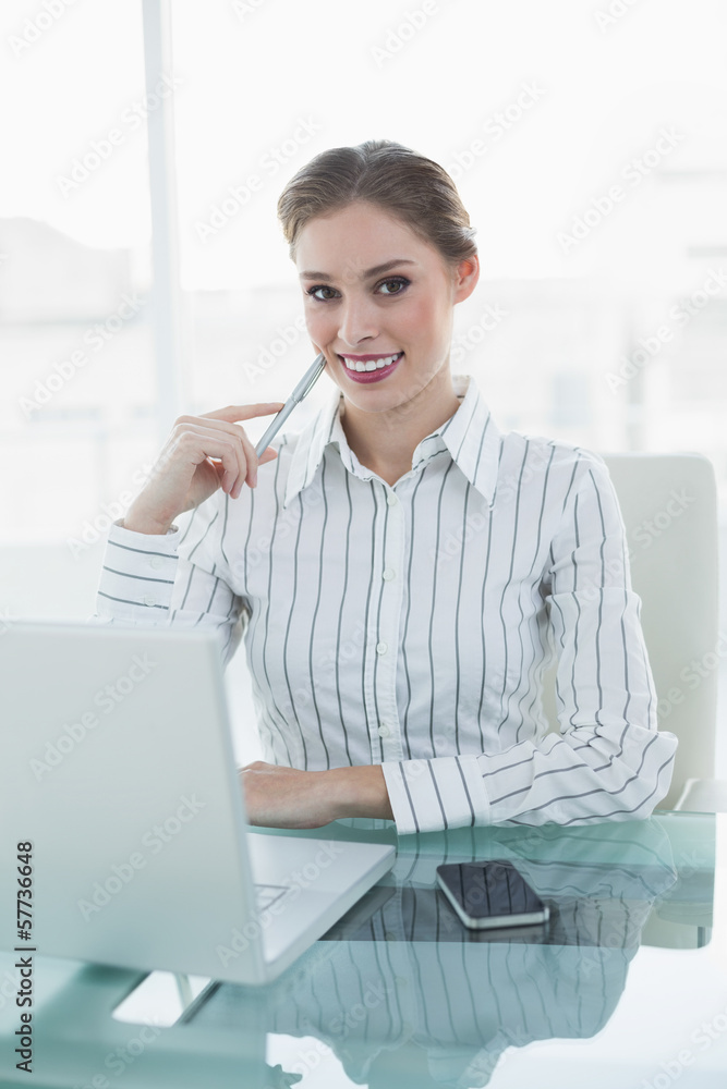 © lightwavemedia - Smiling chic businesswoman sitting at her desk in front of lapto © lightwavemedia - Smiling chic businesswoman sitting at her desk in front of lapto