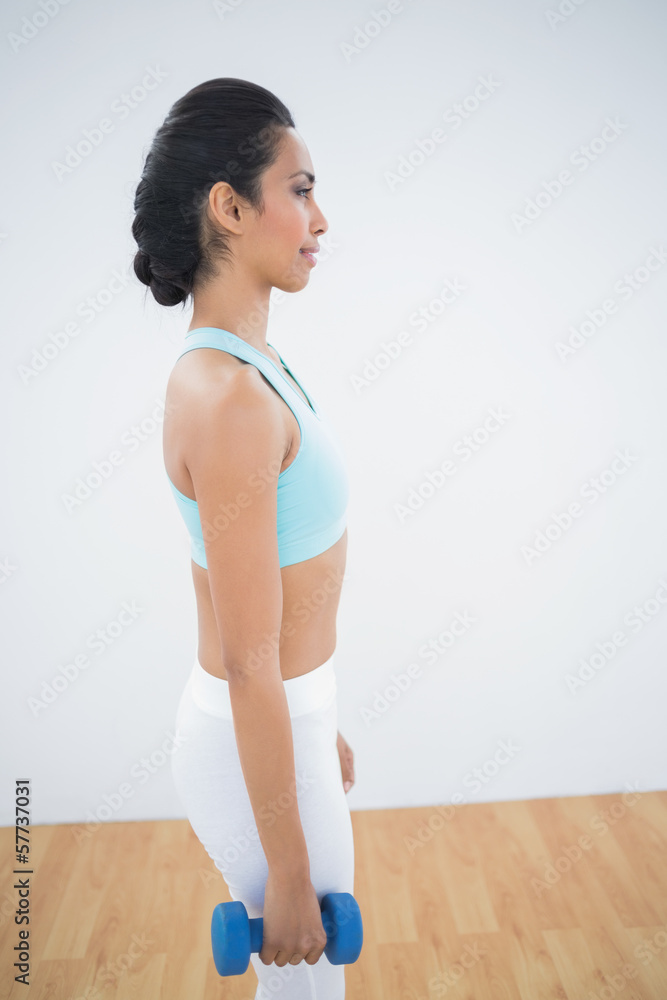 Calm sporty woman holding dumbbells