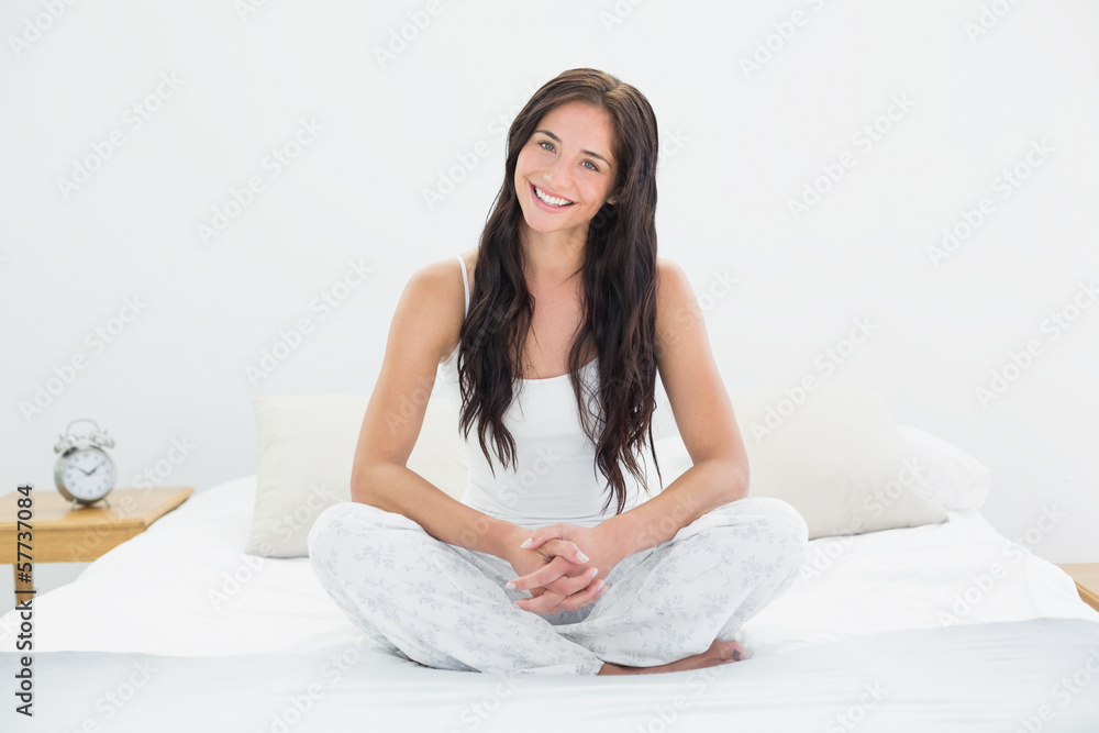 Woman sitting and smiling in bed Woman sitting and smiling in bed