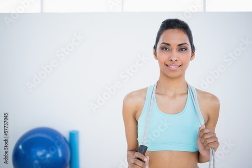 Beautiful woman in sportswear posing holding a rope