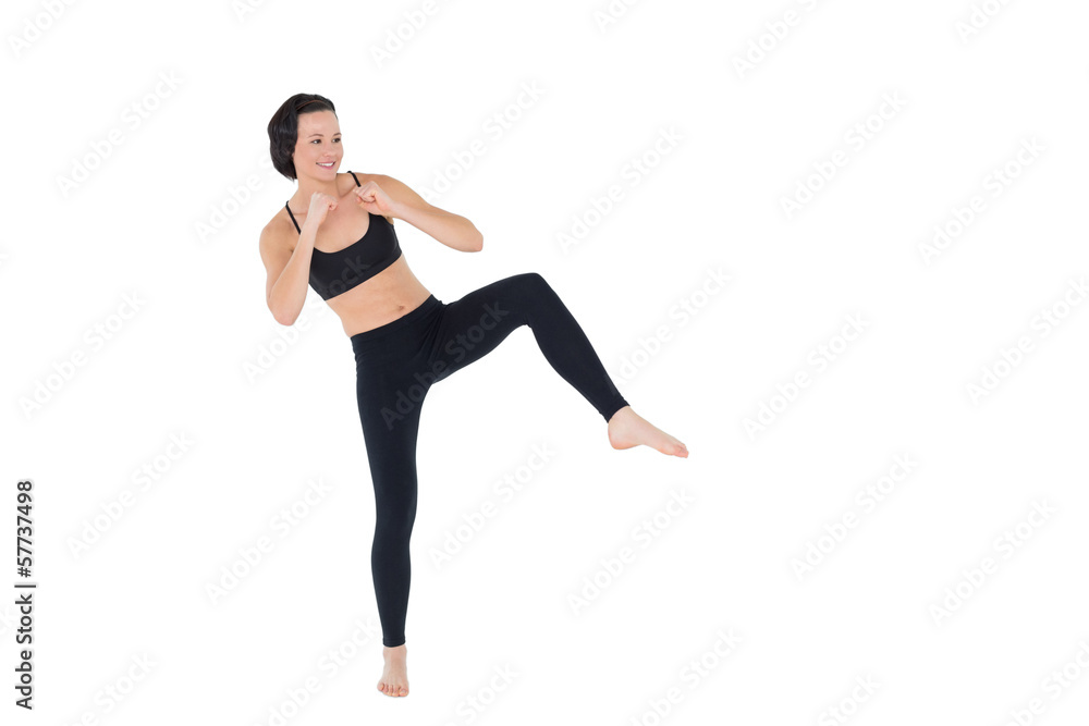 Sporty woman air kicking over white background