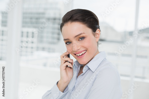 Cheerful elegant businesswoman using cellphone