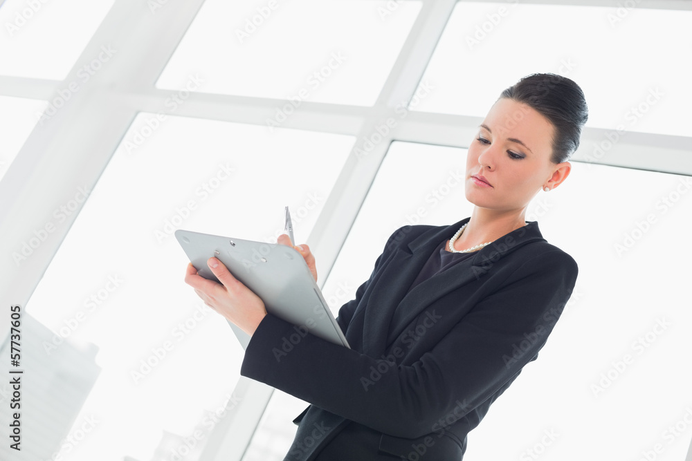 Elegant businesswoman writing notes in office Elegant businesswoman writing notes in office