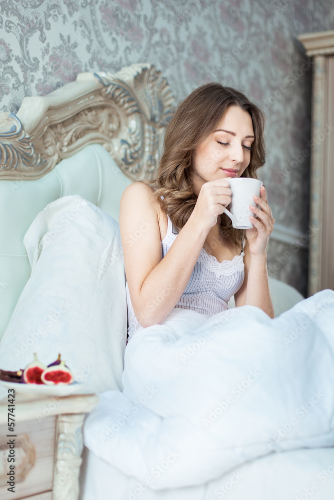 Attractive woman with a cup on the bed Attractive woman with a cup on the bed