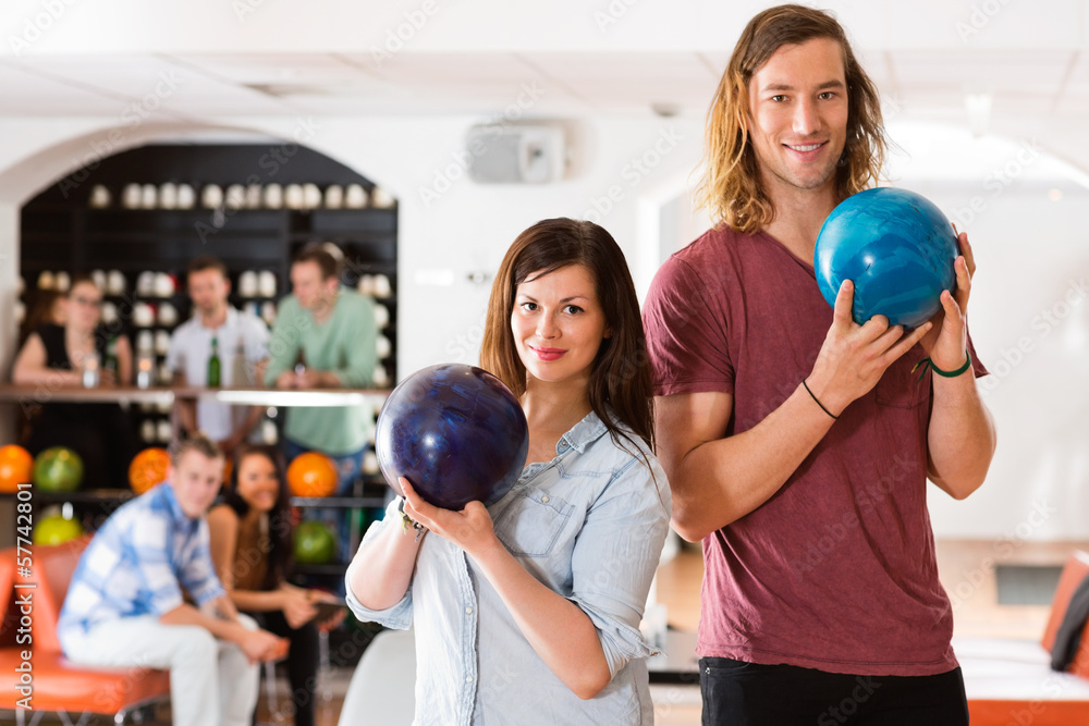 Man And Woman Holding Bowling Balls in Club
