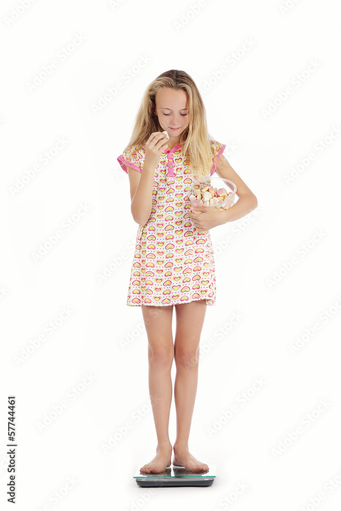jeune fille se pesant avec paquet de sucreries jeune fille se pesant avec paquet de sucreries