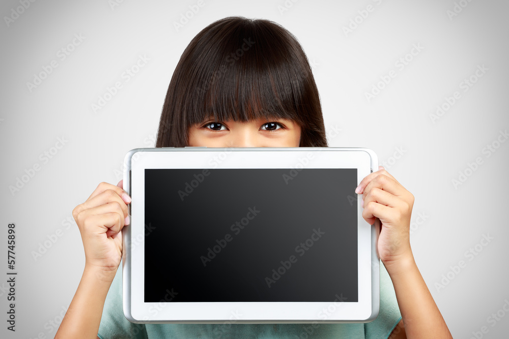 Little girl holding up a blank tablet computer obscuring the low Little girl holding up a blank tablet computer obscuring the low