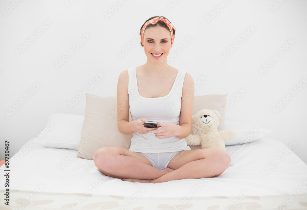 Smiling young woman holding her smartphone Smiling young woman holding her smartphone